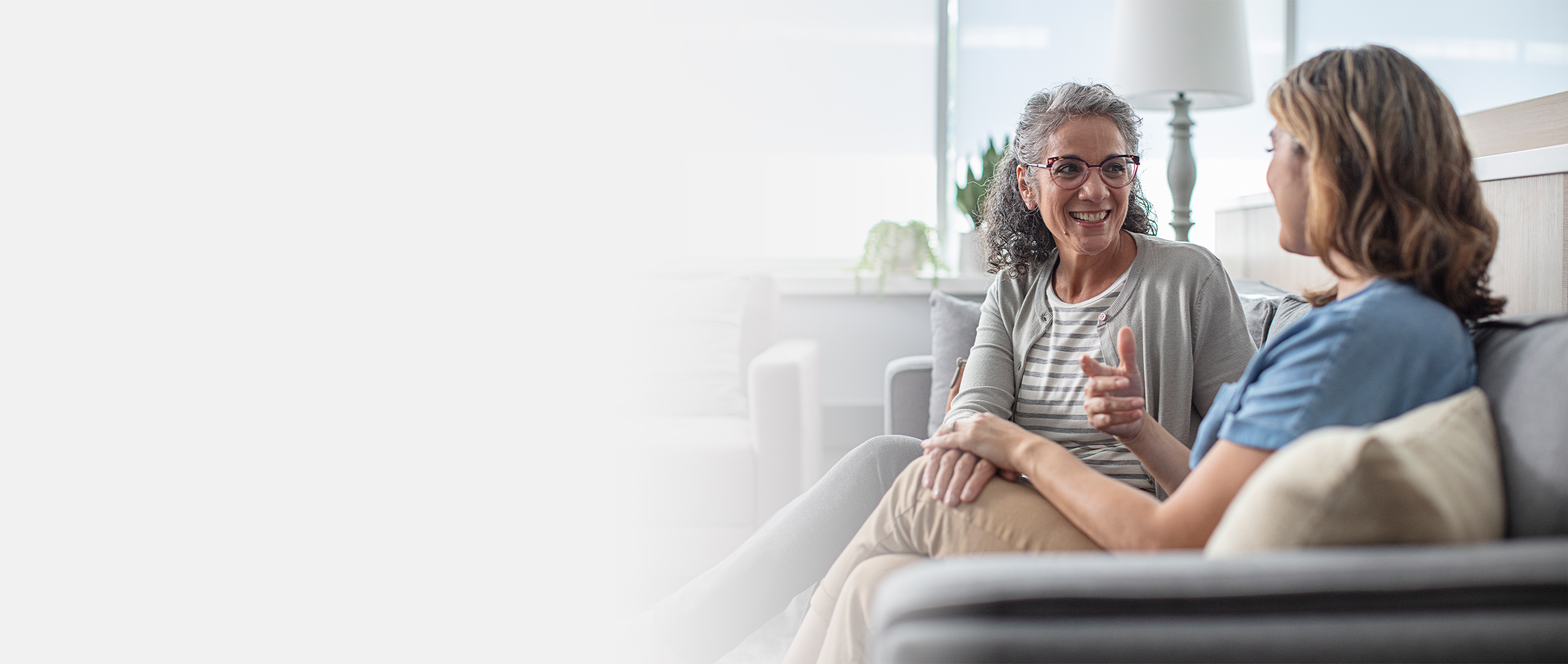 Two women speaking on a couch