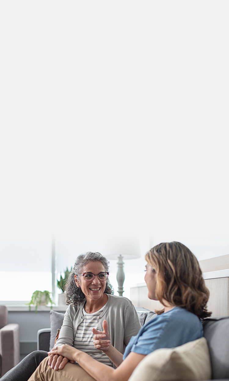 Two women speaking on a couch